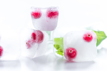 Ice cubes with berries and mint for summer drink on white background