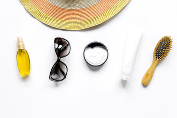 Summer rest with protiction cream, hat, comb white desk top view space for text