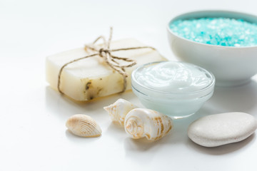 Obraz na płótnie Canvas blue set for bath with salt and shells on white table background