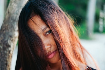 Natural portrait of beautiful young Asian girl smiling with messy hair