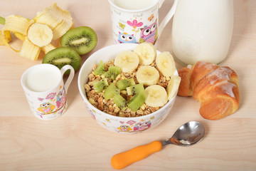 Delicious breakfast for children with kiwi and banana and breakfast cereal and milk
