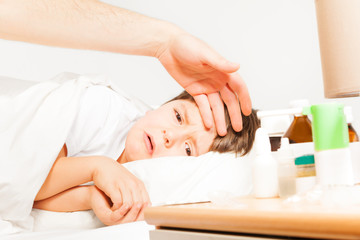 Obraz na płótnie Canvas Boy crying while father measuring his temperature