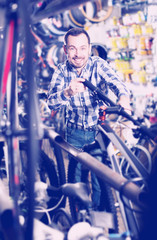 Obraz na płótnie Canvas Man considers bicycle handlebar in store