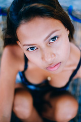 Portrait of young sexy beautiful girl sitting on rattan hammock on the beach during the summer