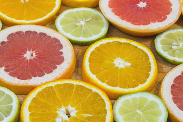 Fototapeta na wymiar Citrus fruit background with sliced f oranges lemons lime tangerines and grapefruit