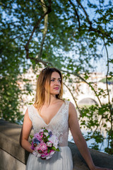 Bride and groom wedding poses under trees on the bank of the river Tiber, Rome, Italy