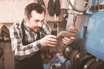 Mn worker repairing footwear in repair workplace