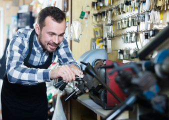 Young man worker working at forming key