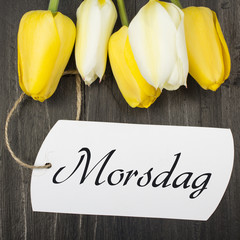 Mother's Day card with Norwegian words: Mother's Day, and tulip bouquet and blank card on dark wooden table © czarny_bez