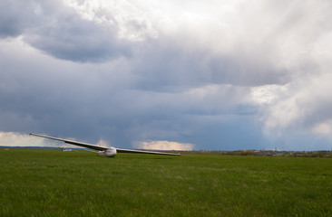 Two gliders are waiting for the tow plane on green grass