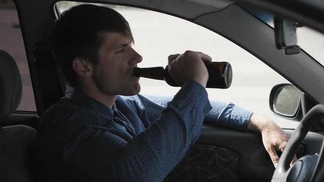 Man drinking beer in car. Drunk driver