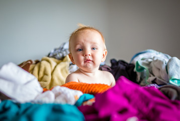 Cute Baby Disrupts Household Chores by Sitting in Pile of Clothes on Bed