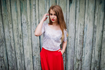 Fototapeta premium Portrait of beautiful girl with red lips against wooden background, wear on red dress and white blouse.