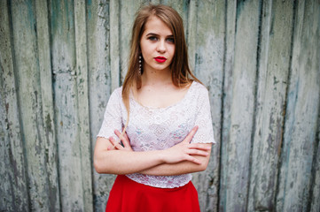 Fototapeta premium Portrait of beautiful girl with red lips against wooden background, wear on red dress and white blouse.