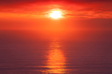 Fototapeta na wymiar Orange Sunset with sea reflection