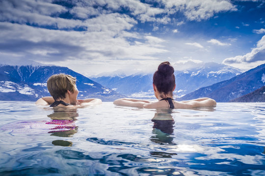 Frauen im Urlaub geniessen Bergpanorama vom Pool aus