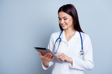 Portrait of pretty happy  doctor using digital tablet and push touchscreen in her job