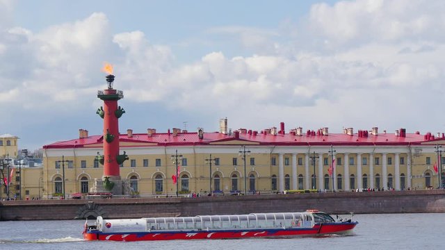 The boat sails past the embankment with a column