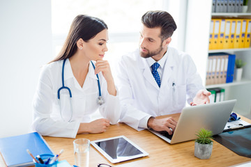 Photo of two doctors together discussing new way of treatment while having a meeting at office