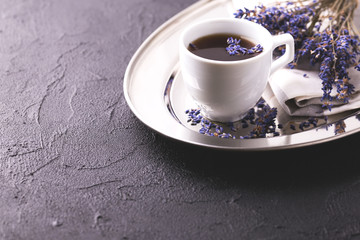 Cup of coffee with lavender flowers on table