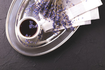 Cup of coffee with lavender flowers on table
