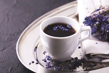 Cup of coffee with lavender flowers on table