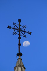 Fototapeta na wymiar Cruz de hierro forjado en firmamento con luna.