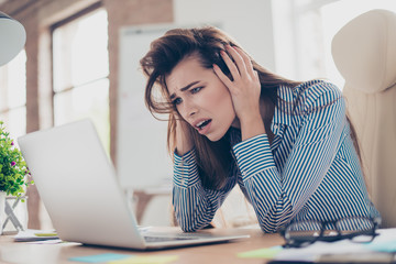 No way! Shocked and frustrated young cute lawyer is looking at the screen of her laptop. Bad mood