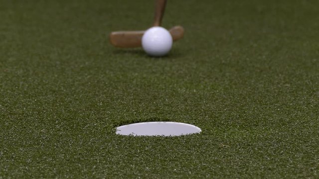 Golf Ball Rolling Into Hole.