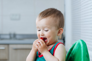 the child in the kitchen eating strawberries