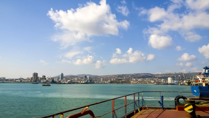 View of the sea and city beach from the port quay. Industrial po