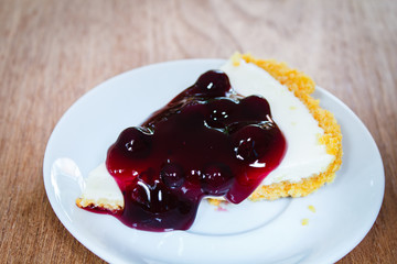 Blueberry cheesecake on wood plate.