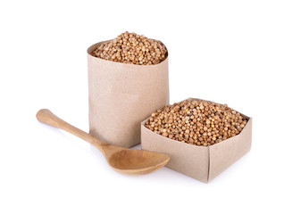 dried coriander seeds in paper bag and box on white background
