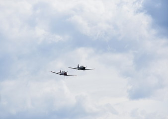 Airplane aerobatics, two airplanes flying together on an airshow.