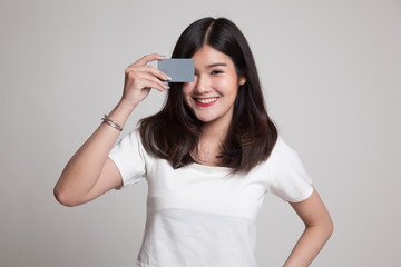 Young Asian woman with  blank card over her eye.