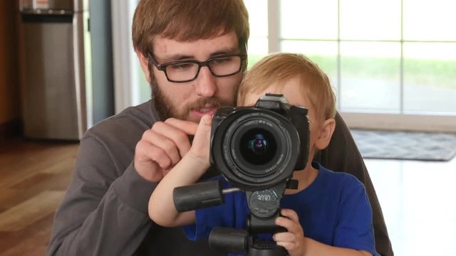 Father showing son how to use a camera