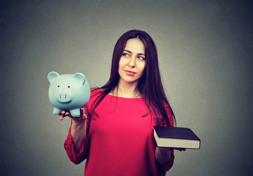 Cost of college education. Thoughtful woman balancing piggy bank and book