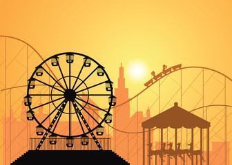 Silhouettes of a city and amusement park .