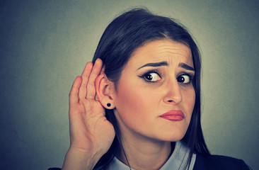 Woman with hand to ear gesture listening carefully