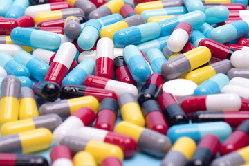 many scattered Colorful pills on blue background.