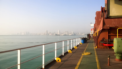 View of the sea and city beach from the port quay. Industrial po