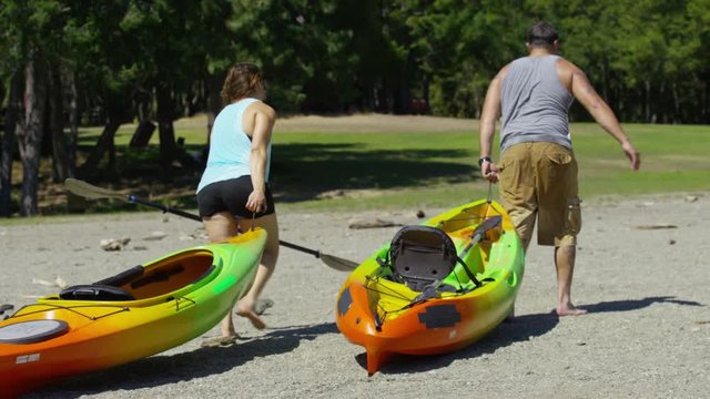 Couple Carry Kayaks To Lake