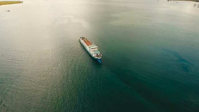 Aerial view Cargo and passenger ships in a beautiful lagoon on Siargao. Flying over the water surface of the sea with ships, blue sky and clouds. 4K video. Aerial footage. Philippines, Manila.
