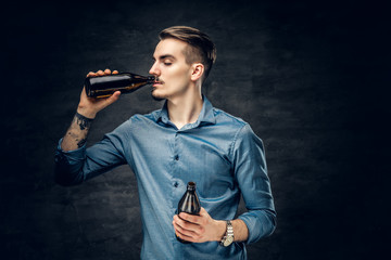 Fototapeta premium A man drinks craft bottled beer.