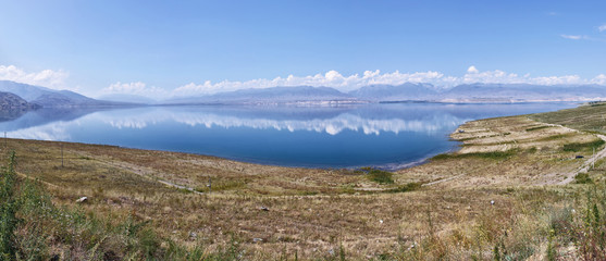 Kyrgyzstan, Toktogul lake. The road from Bishkek to Osh. Big mountain lake in Kyrgyzstan, blue, sunny weather, around the mountain.