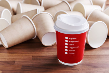 Red paper coffee cup with brown paper cups background