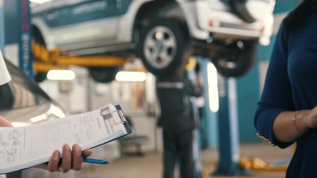 Auto service - woman gives the keys of car for mechanic