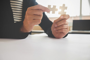Business man hands connecting jigsaw puzzle. Business solutions success and strategy concept. Businessman concept. Close up photo with selective focus.