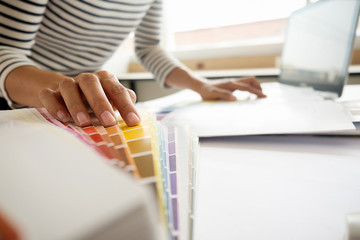 Graphic design and color swatches and pens on a desk. Architectural drawing with work tools and accessories.