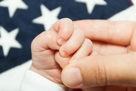 Handle of a child in the mother's hand.